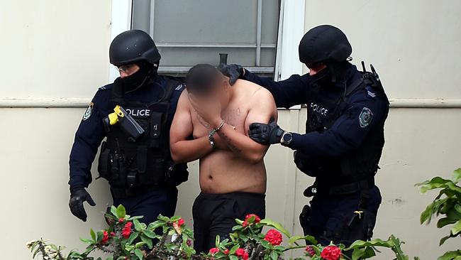 A man is led away by specialist police yesterday. Picture: NSW Police