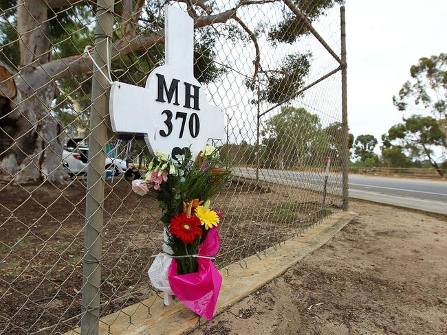 Flowers and a memorial for the missing passengers of flight MH370 are attached to the perimeter fence of RAAF Pearce Airbase near Perth. Picture: Getty Images