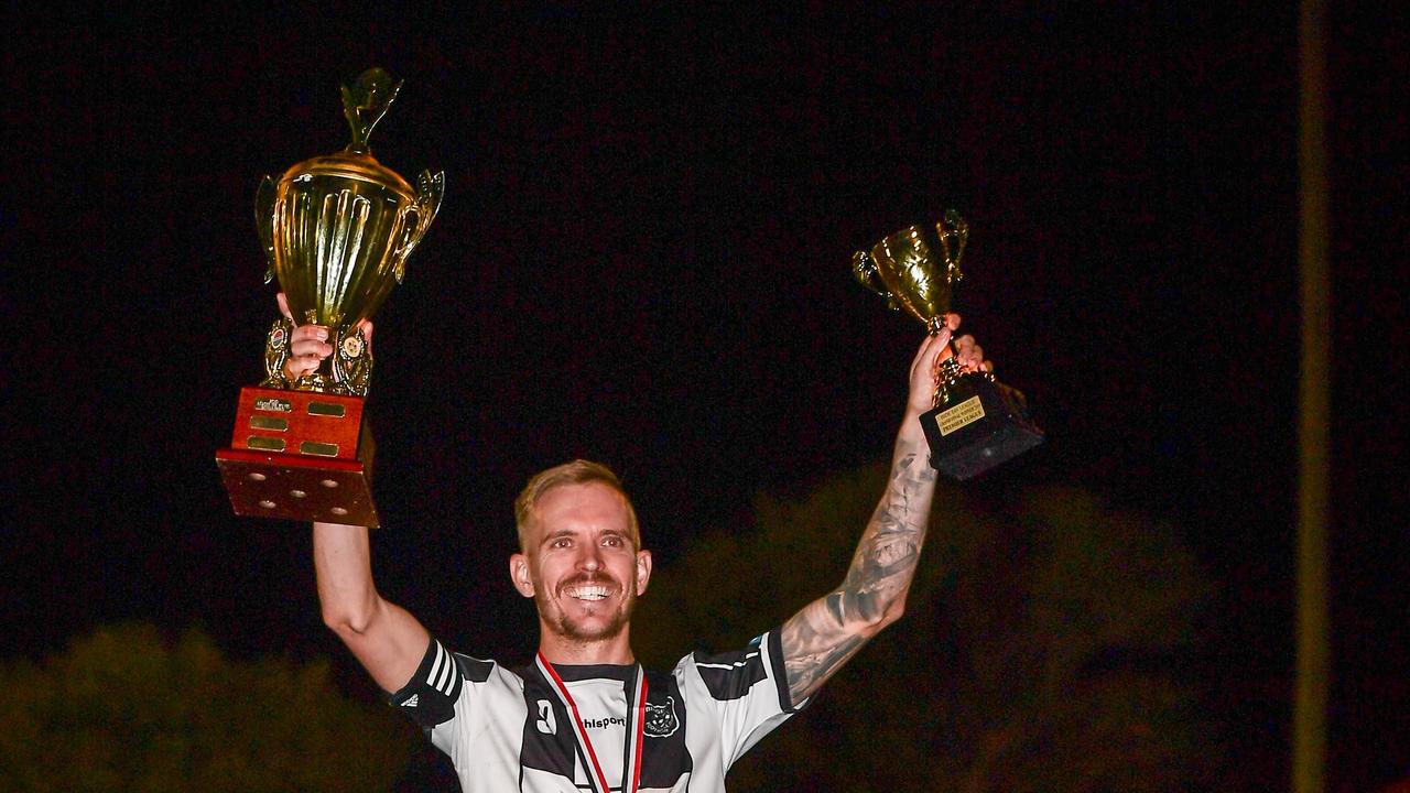 Stripeys Daniel Watson holds the silverware aloft after winning the Wide Bay Premier League Grand Final.