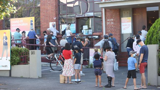 Parents and children line up at a West Melbourne vaccination clinic on Monday. Picture: David Caird