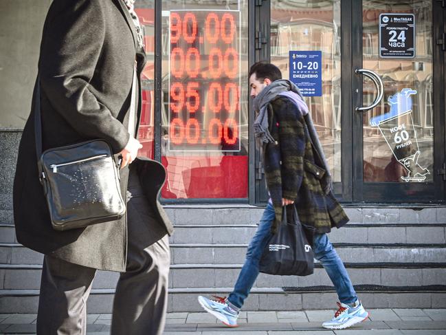 People walk past a currency exchange office in central Moscow. The Russian ruble collapsed against the dollar and the euro on the Moscow Stock Exchange. Picture: AFP