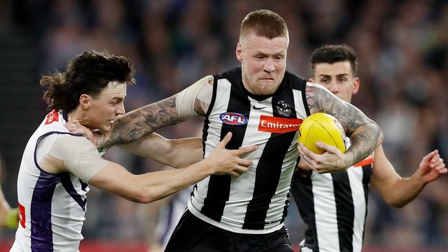 Jordan De Goey shrugs off Jordan Clark. Picture: Dylan Burns/AFL Photos via Getty Images