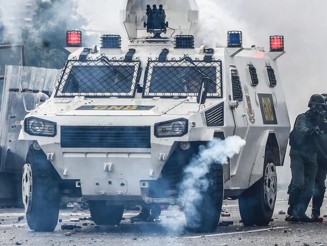 Riot police officers confront opposition activists during a march against Venezuelan President Nicolas Maduro last week. Security forces in riot vans blocked off central Caracas one month after a wave of deadly political unrest erupted. Picture: Juan Barreto/AFP