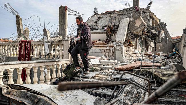 A man salvages the remains of a copy of the Koran, Islam's holy book, from the rubble of a building that was hit overnight during Israeli bombardment in Rafah in the southern Gaza Strip on March 26. Picture: Said Khatib/AFP