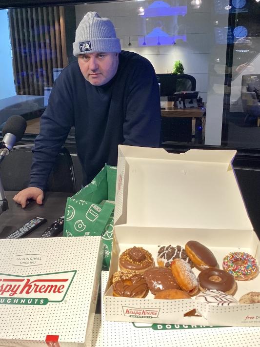 Craig Hutchison with 10 boxes of Krispy Kreme doughnuts that were sent to his radio show. Picture: Supplied.