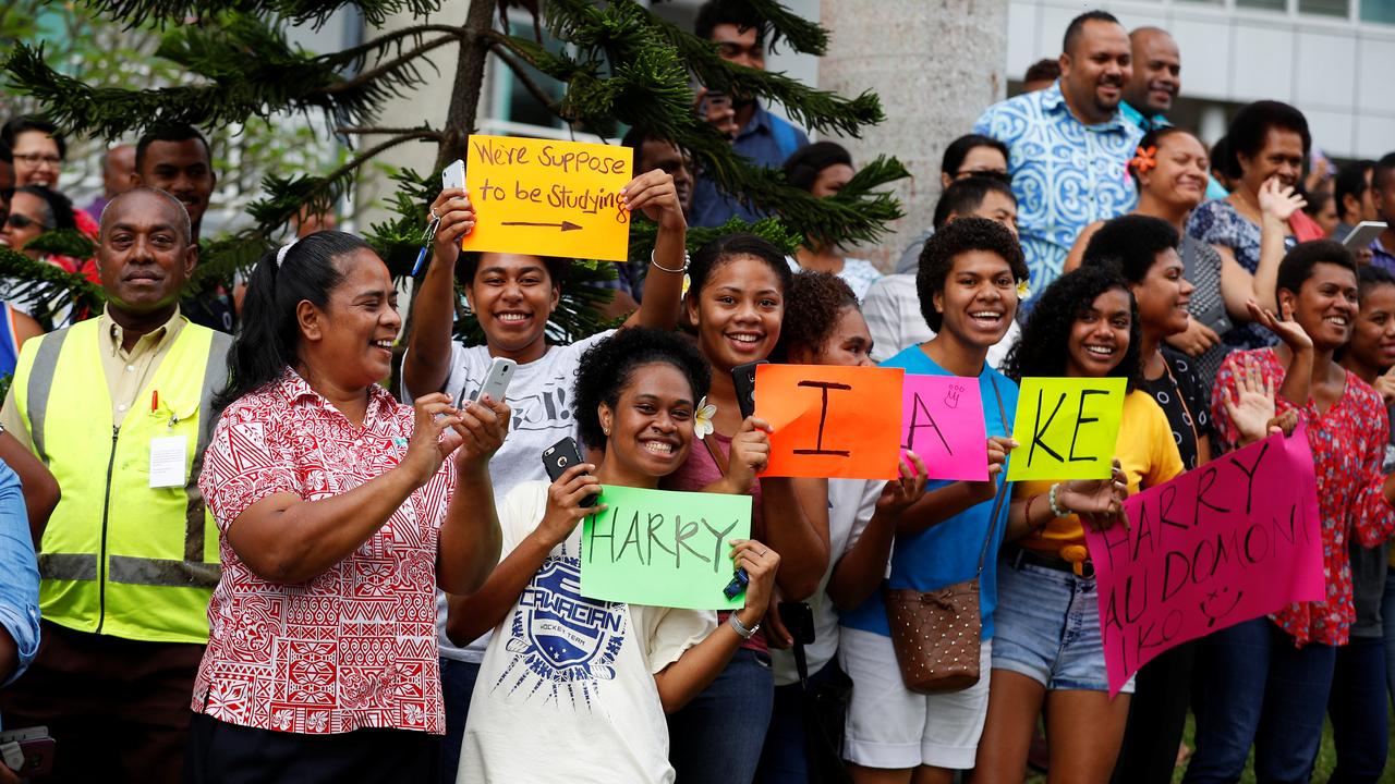 Students hold up signs welcoming Prince Harry to the University of the South Pacific on Wednesday. Picture: Phil Noble.