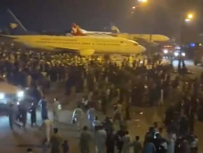 People flood the runway at Kabul airport.