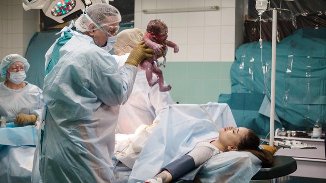 A doctor shows Elyzaveta her newborn son in a Kyiv maternity hospital on Wednesday. Picture: Getty Images