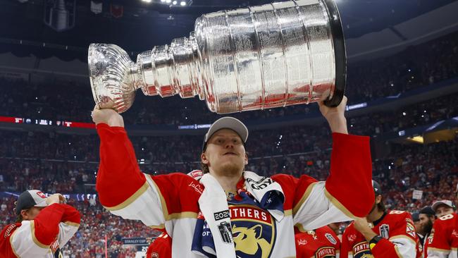 SUNRISE, FLORIDA - JUNE 24: Niko Mikkola #77 of the Florida Panthers hoist the cup after Florida's 2-1 victory against the Edmonton Oilers in Game Seven of the 2024 Stanley Cup Final at Amerant Bank Arena on June 24, 2024 in Sunrise, Florida. (Photo by Bruce Bennett/Getty Images)