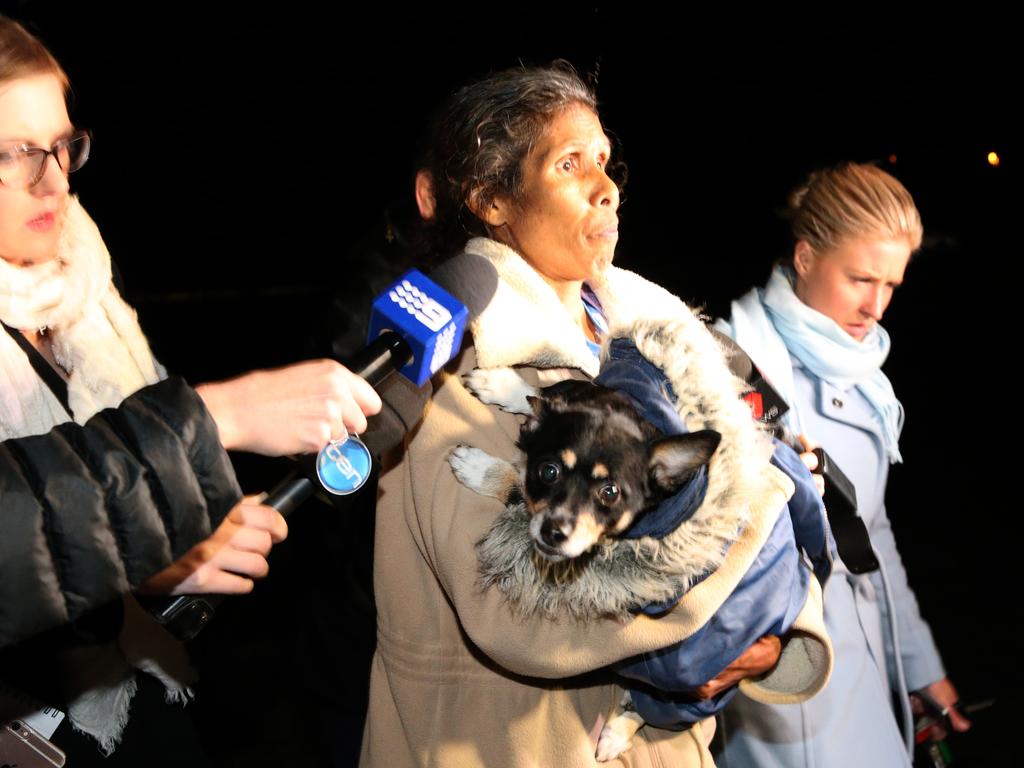 A dog is taken from the property by family on the day the bodies were found. Picture: Stephen Laffer