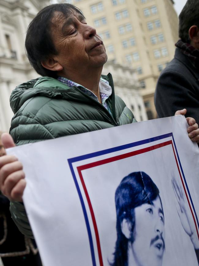 People hold banners of missing relatives during the anniversary on September 11 of the 1973 military coup. Picture: AP/Esteban Felix