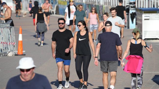 Keep walking and avoid eye contact … people at Bondi on Tuesday morning. Picture: David Swift.