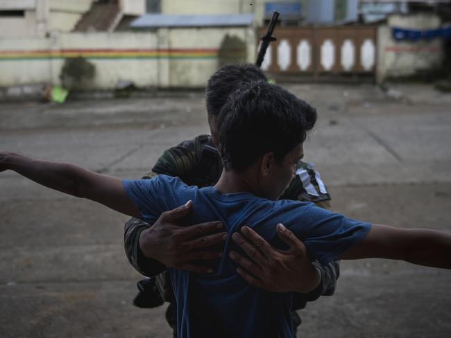 A resident who escaped from Marawi City is frisked by local police as part of their security processing. Picture: Jes Aznar/Getty Images