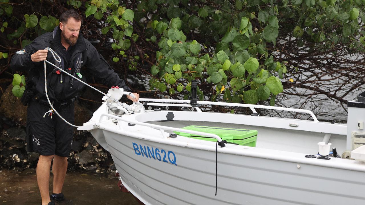 A police officer secures a boat involved in the Broadwater incident. Picture: Nigel Hallett