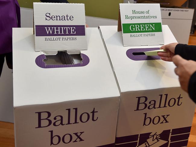 A man puts his voting paper in the ballot box for the Australian Federal Election in Melbourne on July 2, 2016.  Australia is voting in a general election which is expected to be a close race between the ruling Liberal-National coalition and the opposition Labor Party. / AFP PHOTO / Paul Crock