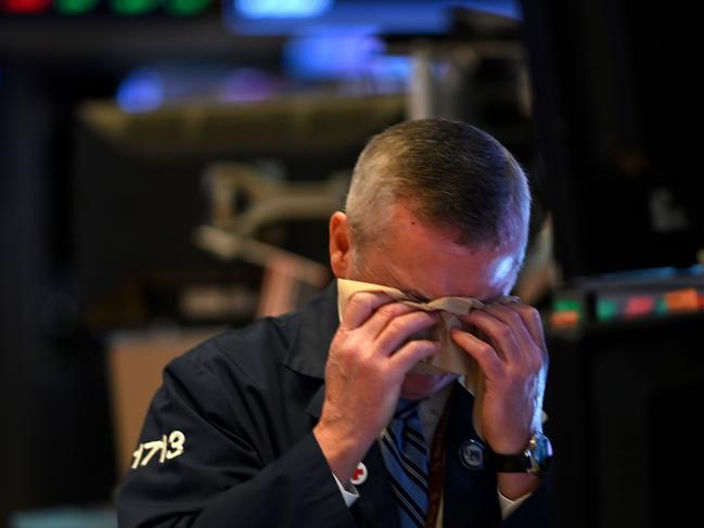 A trader wipes his face as he works during the closing bell. Picture: AFP