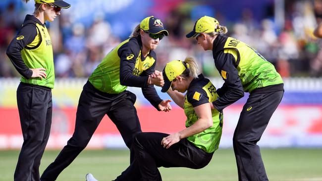 Australia's Ellyse Perry is helped to her feet by teammates after being injured in their T20 World Cup clash with New Zealand. Picture: AFP