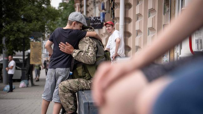 A young boy hugs a member of Wagner group in Rostov-on-Don. Picture: AFP