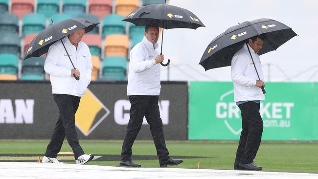 Umpires, from left, Mick Martell, Richard Kettleborough and Aleem Dar inspect the pitch as rain stops play in the second Test between Australia and South Africa at Blundstone Arena. Picture: ROBERT CIANFLONE/GETTY IMAGES