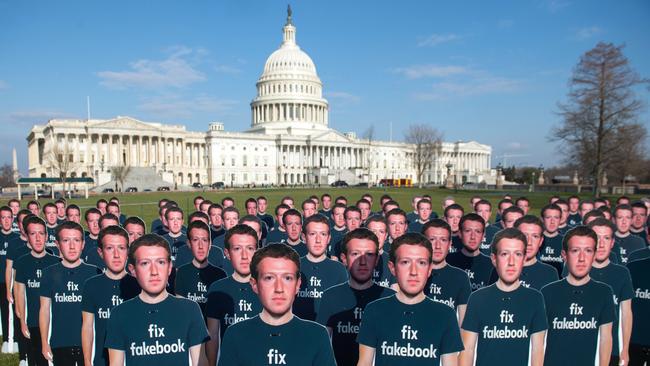 (FILES) In this file photo taken on April 10, 2018 One hundred cardboard cutouts of Facebook founder and CEO Mark Zuckerberg stand outside the US Capitol in Washington, DC. It has turned into a brutal reality check for Facebook. The social network star -- which had weathered storms over privacy and data protection -- is now looking ahead at a cloudier financial future that threatens to end its years-long breakneck growth pace. Shares in Facebook plummeted 19 percent to $175.30 in early trade Thursday, wiping out some $100 billion -- believed to be the worst single-day evaporation of market value for any company. / AFP PHOTO / SAUL LOEB