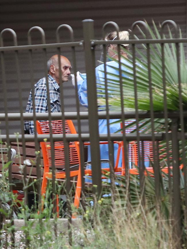 A resident at Newmarch Nursing Home, at which one of the nation’s biggest clusters of COVID-19 occurred, is escorted by a staff member in April. Picture: Richard Dobson