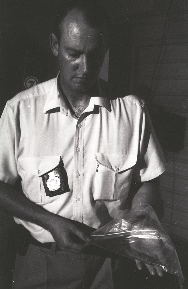 A police officer at the scene holding the knife which was found.