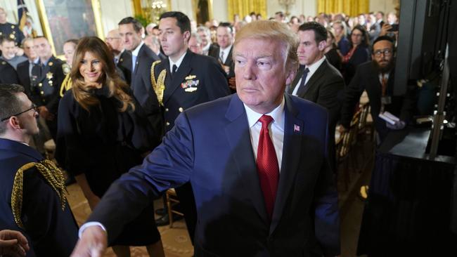 President Donald Trump and first lady Melania Trump, left, leave the East Room of the White House. Picture: AP