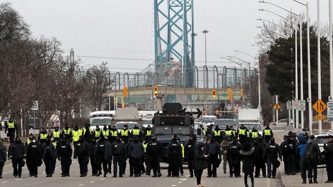 Police gather to clear protesters who blocked the entrance to the Ambassador Bridge in Windsor, Ontario, Canada. Picture: AFP.