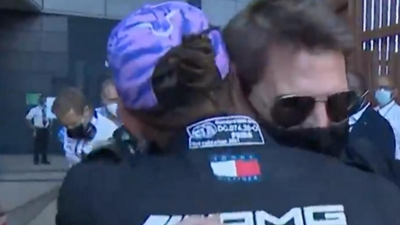 Tom Cruise embraces Lewis Hamilton.