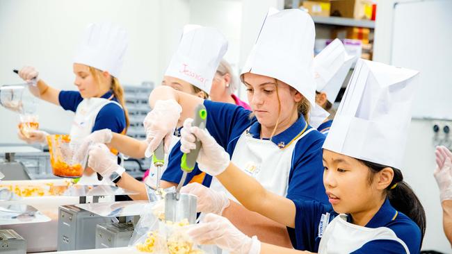 Local Girl Guides preparing food at FareShare, Morningside. PICTURE: AAP/Richard Walker