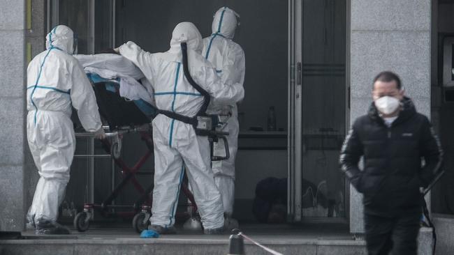 Medical staff transport a victim of the mystery coronavirus at Hinyintan hospital, Wuhan