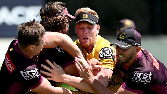 Thomas Flegler is wrapped up by the defence during a Brisbane Broncos NRL training session at Clive Berghofer Centre on March 07, 2022 in Brisbane, Australia. (Photo by Bradley Kanaris/Getty Images)