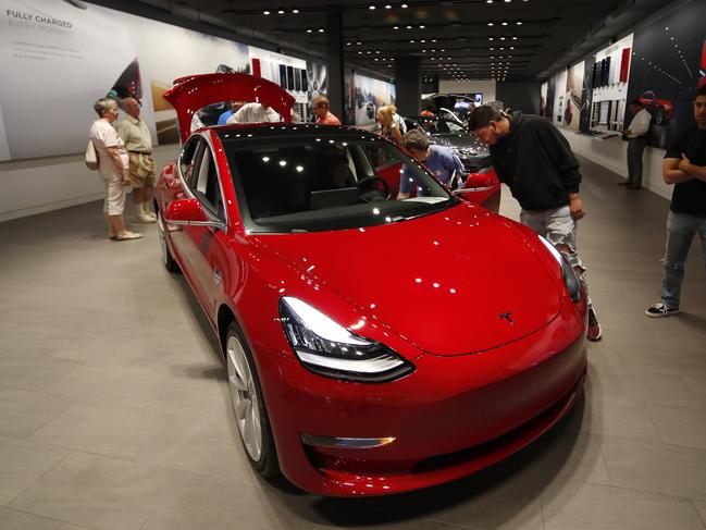 In this Friday, July 6, 2018, photograph, prospective customers confer with sales associates as a Model 3 sits on display in a Tesla showroom in the Cherry Creek Mall in Denver.  The Insurance Institute for Highway Safety, in a paper titled â€œReality Check,â€ issued the warning Tuesday, Aug. 7, 2018, after testing five of the systems from Tesla, Mercedes, BMW and Volvo on a track and public roads. The systems tested, in the Tesla Model 3 and Model S, BMWâ€™s 5-Series, the Volvo S-90 and the Mercedes E-Class, are among the best in the business right now and have been rated â€œsuperiorâ€ in previous IIHS tests. David Zuby, the instituteâ€™s chief research officer, said the systems do increase safety but the tests show they are not 100 percent reliable. (AP Photo/David Zalubowski)