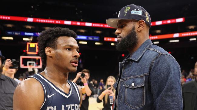 (FILES) In this file photo taken on December 11, 2021 Bronny James #0 of the Sierra Canyon Trailblazers is greeted by his father and NBA player LeBron James after defeating the the Perry Pumas in the Hoophall West tournament at Footprint Center in Phoenix, Arizona. - LeBron James has agreed to terms on a two-year NBA contract extension with the Los Angeles Lakers worth $97.1 million, according to multiple reports on Wednesday. (Photo by Christian Petersen / GETTY IMAGES NORTH AMERICA / AFP)