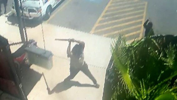 A group of a dozen men and women engage in conflict brandishing weapons - including machetes and baseball bats - outside The Gap View Hotel in Alice Springs in September.