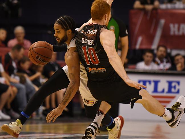 Melo Trimble hurt his wrist in this clash with Hawk Angus Glover. Picture: AAP