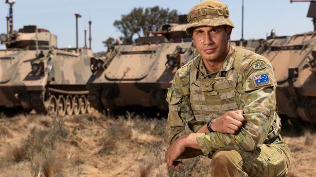 Australian Army soldier Corporal Josh Green from B Squadron 3rd/4th Cavalry Regiment, School of Armour, in front of a M113 AS4 and two autonomous M113 AS4 optionally crewed combat vehicle. Picture: Cpl Tristan Kennedy