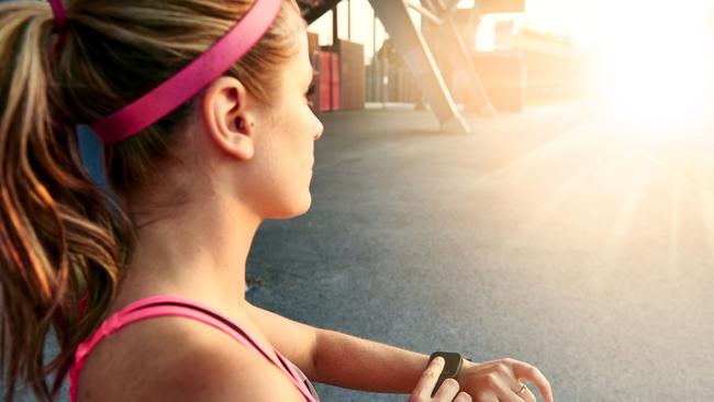 A young woman running with a smartwatch that can also be used to pay.