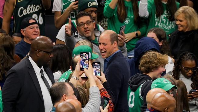 Fans take pictures of Prince William as he walks away during half-time of the Boston Celtics-Miami Heat NBA game. Picture: AFP