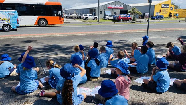 Yamba Public School students wave to a passing bus during a survey done last week.