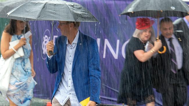 Punters rush in from the station with the rain. Picture: Jay Town