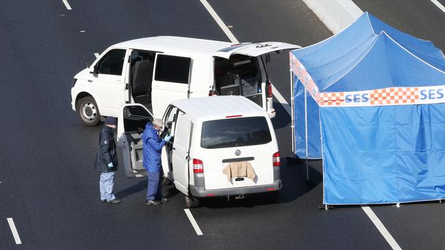 Police gather evidence at the scene on the EastLink. Picture: David Crosling