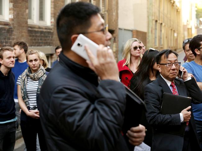 Sydney's narrowest house auction at 29 Terry St Surry Hills. The property sold for $965,000 to a Chinese phone bidder, ( tall asian man with Samsung phone & card 28, closest other bidder was man and woman card 8)  Pic Stephen Cooper