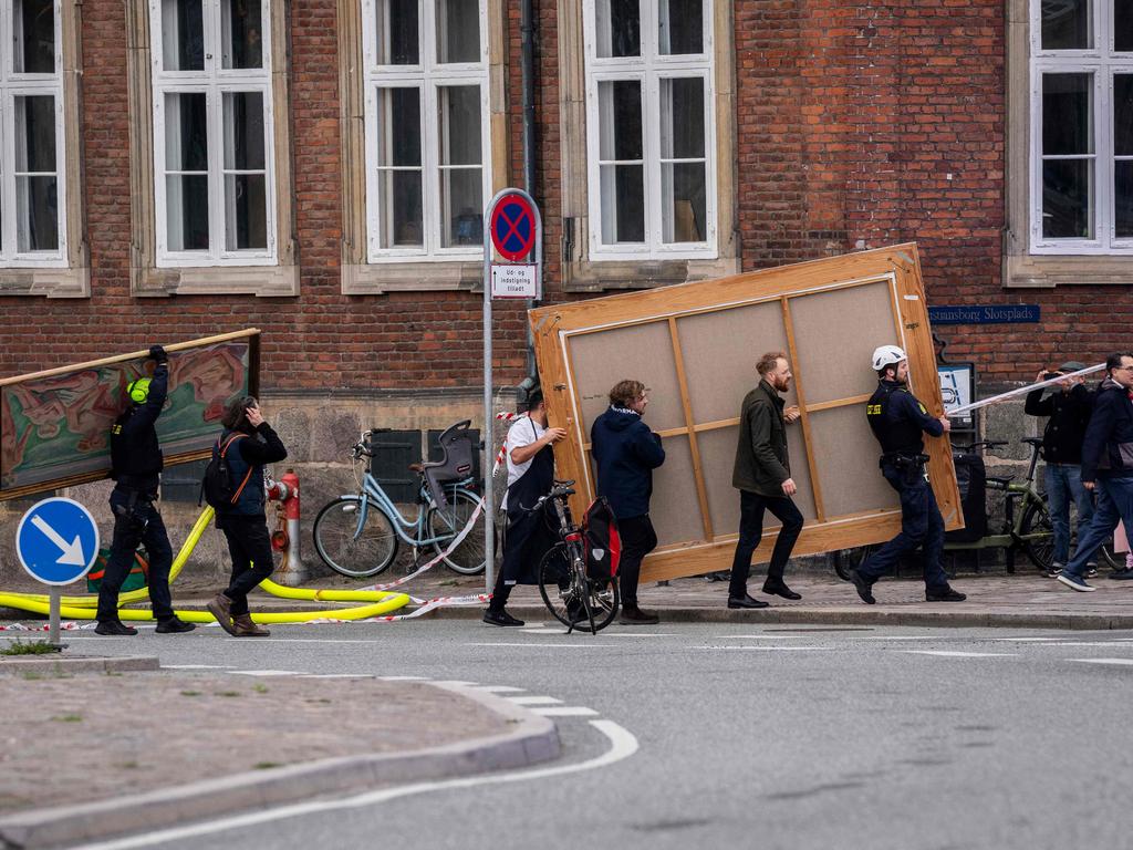 People carry paintings out of the historic Boersen stock exchange building as it is on fire in central Copenhagen, Denmark. Picture: Ida Marie Odgaard / Ritzau Scanpix / AFP / Denmark OUT