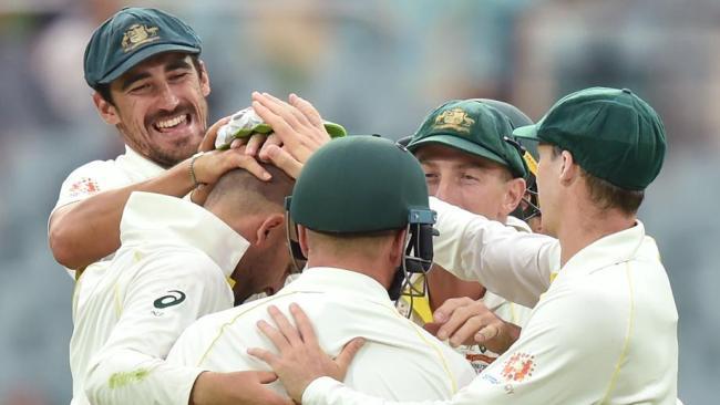 Australian players celebrate after Nathan Lyon took the wicket of Indian captain Virat Kohli.