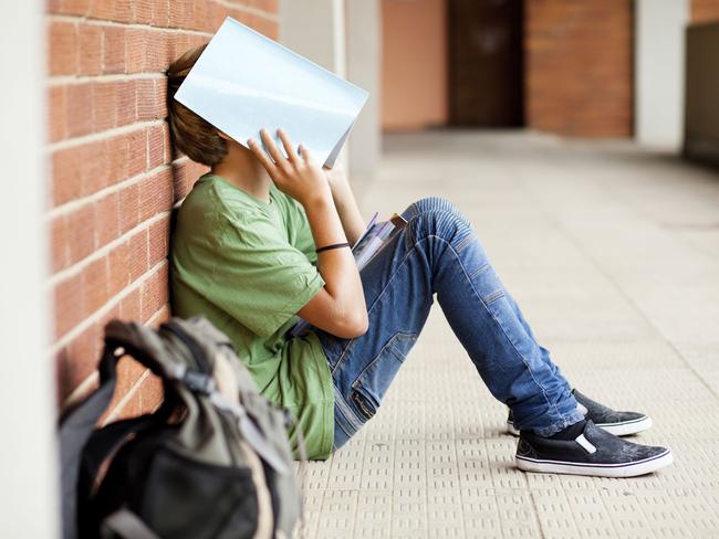 Naughty student waits outside the classroom.