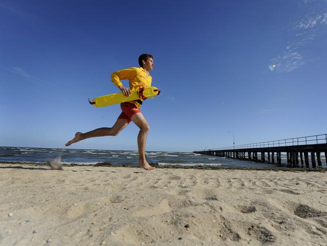 A lifesaver running along Altona Beach following a rescue.