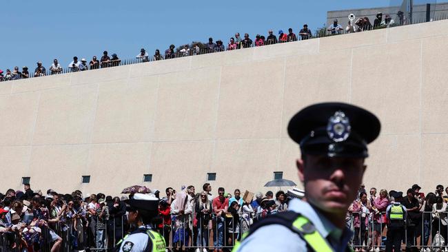 Police keep watch as people wait to see Britain’s King Charles III and Queen Camilla outside Parliament House in Canberra on October 21, 2024, during a six-day royal visit to Sydney and Canberra. Picture: David GRAY / POOL / AFP