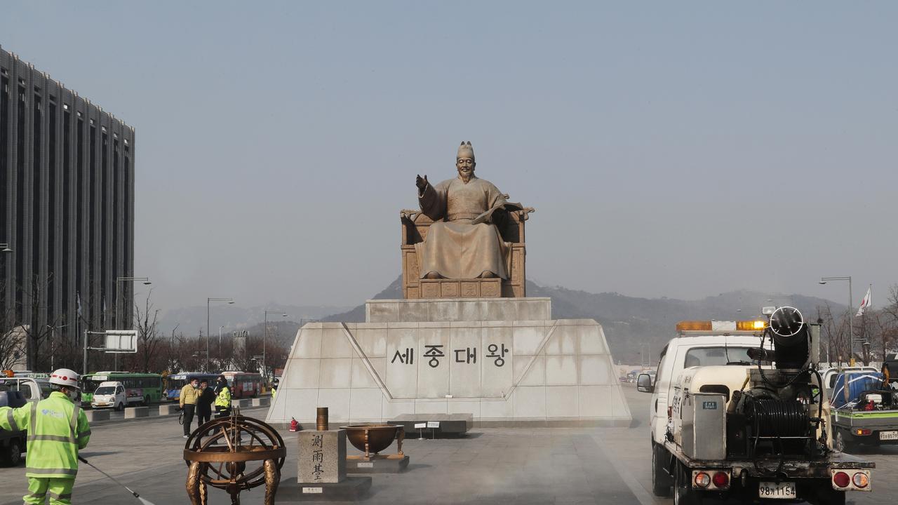 A worker and vehicle spray disinfectant and water as a precaution against the new coronavirus in front of the statue of King Sejong in the Joseon Dynasty, at the Gwanghwamun Plaza in Seoul. Picture: Ahn Young-joon/AP