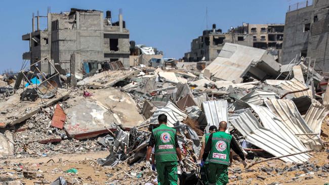 Palestinian paramedics carry away bodies of dead people uncovered in the vicinity of Al-Shifa Hospital in Gaza City. Picture: AFP